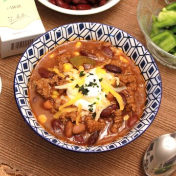 Cowboy chili in a blue white bowl on a brown placemat.