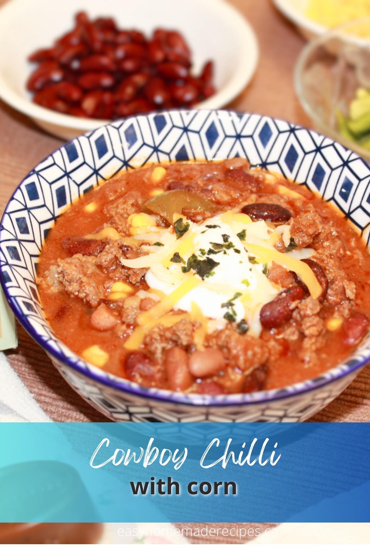 Cowboy chili in a blue white bowl on a brown placemat PIN for Pinterest.