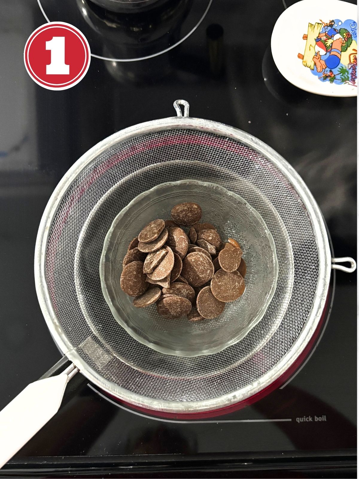 small glass bowl filled with chocolate wafers on a strainer sitting on boiling water