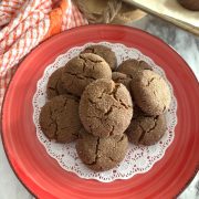 baked ginger snap cookies in a red plate on a doily