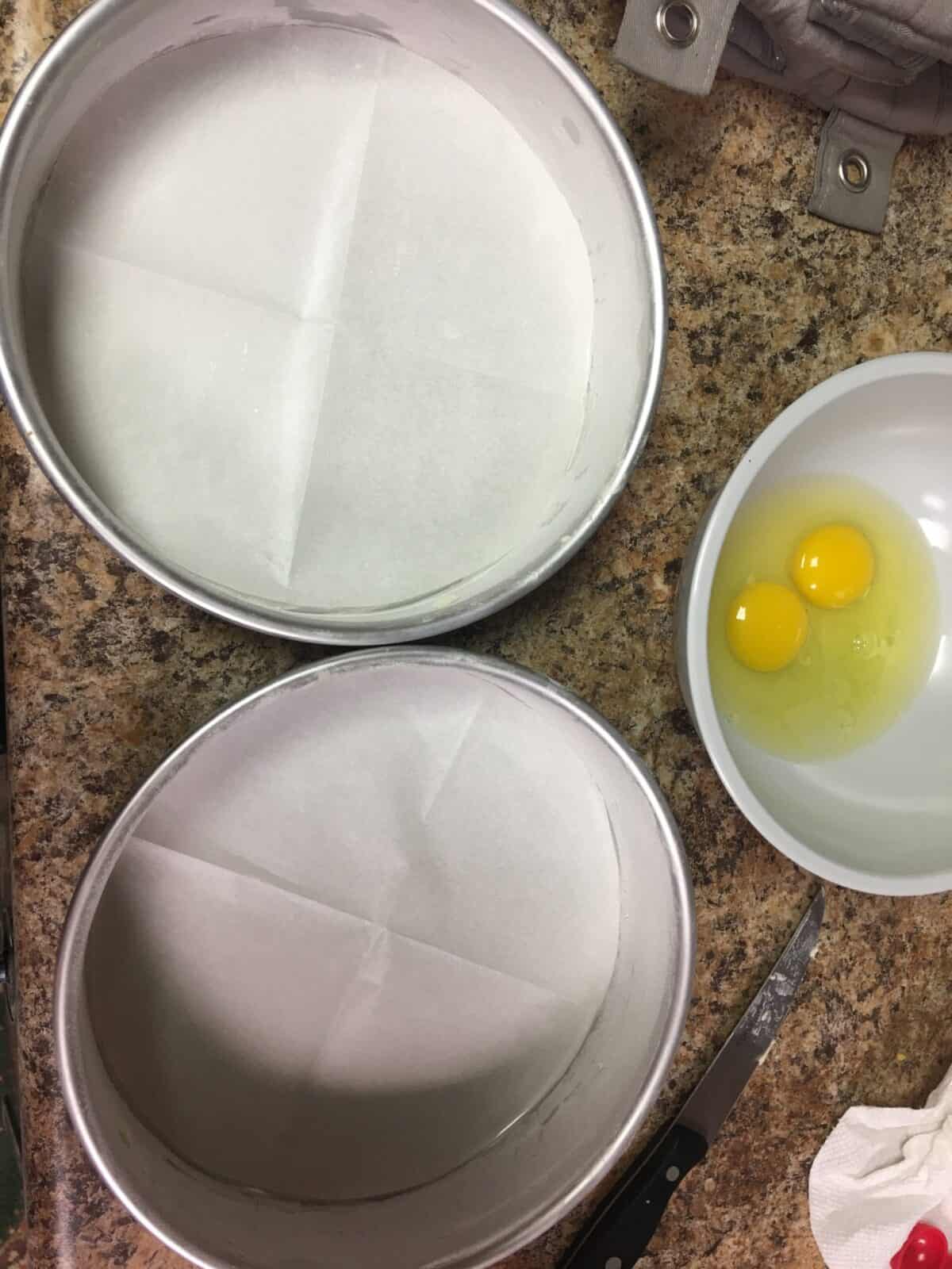 Three cake pans for 3 layer cake on a counter