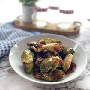 roasted brussel sprouts with bacon and parmesan cheese in a white bowl