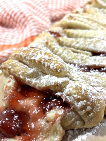 Cherry cream cheese strudel on a wooden cutting board FI