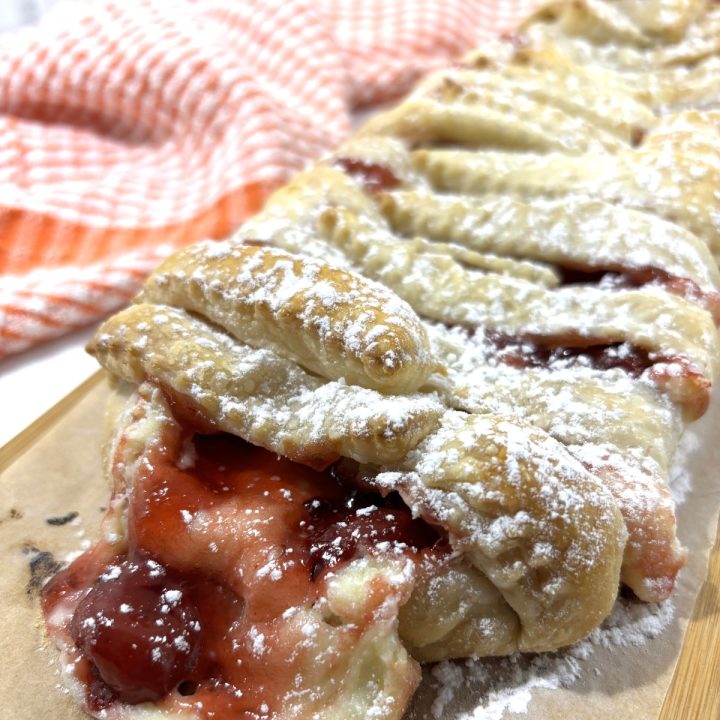 Cherry cream cheese strudel on a wooden cutting board FI