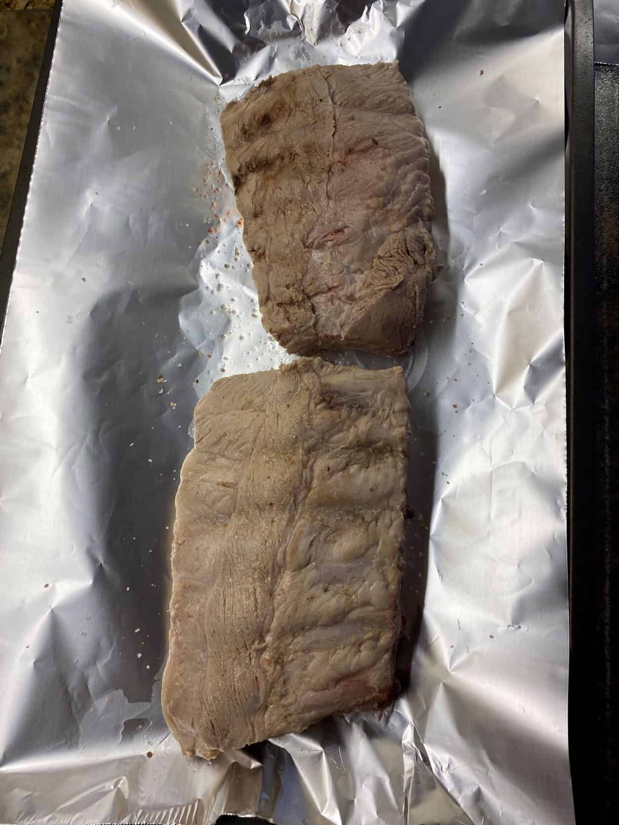 blanched ribs on a baking sheet lined with foil