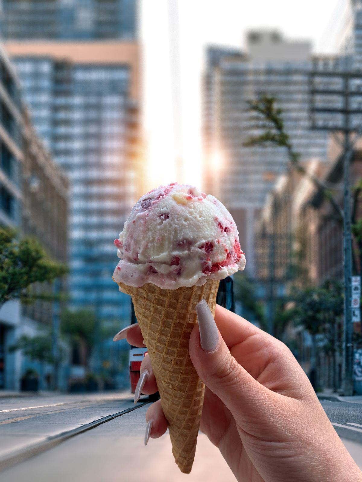 White Chocolate Ice Cream in a sugar cone background of downtown Toronto