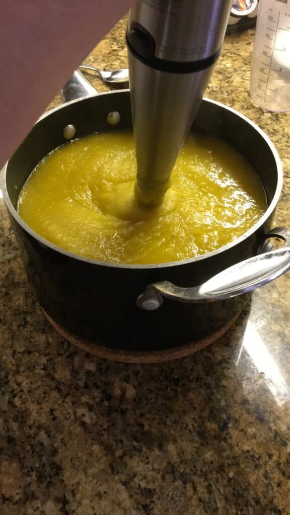 hand mixer pureeing butternut squash into soup