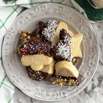Italian butter cookies dipped in chocolate on a white plate