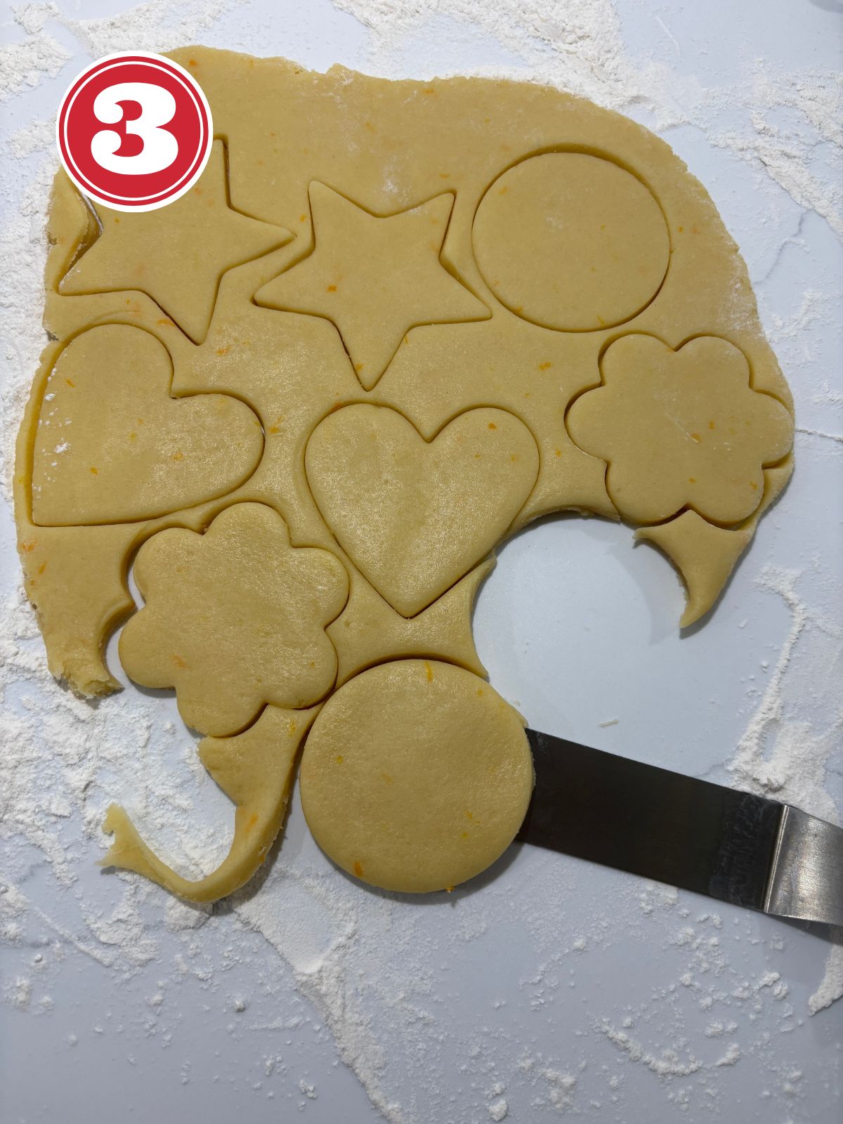 rolled out cookie dough with cut out cookie shapes