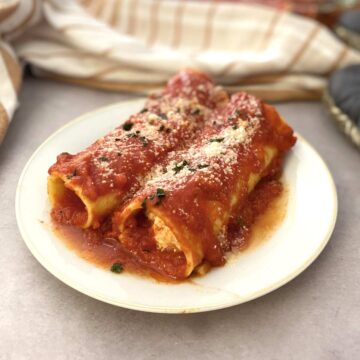 Cheese manicotti in red sauce in a white plate