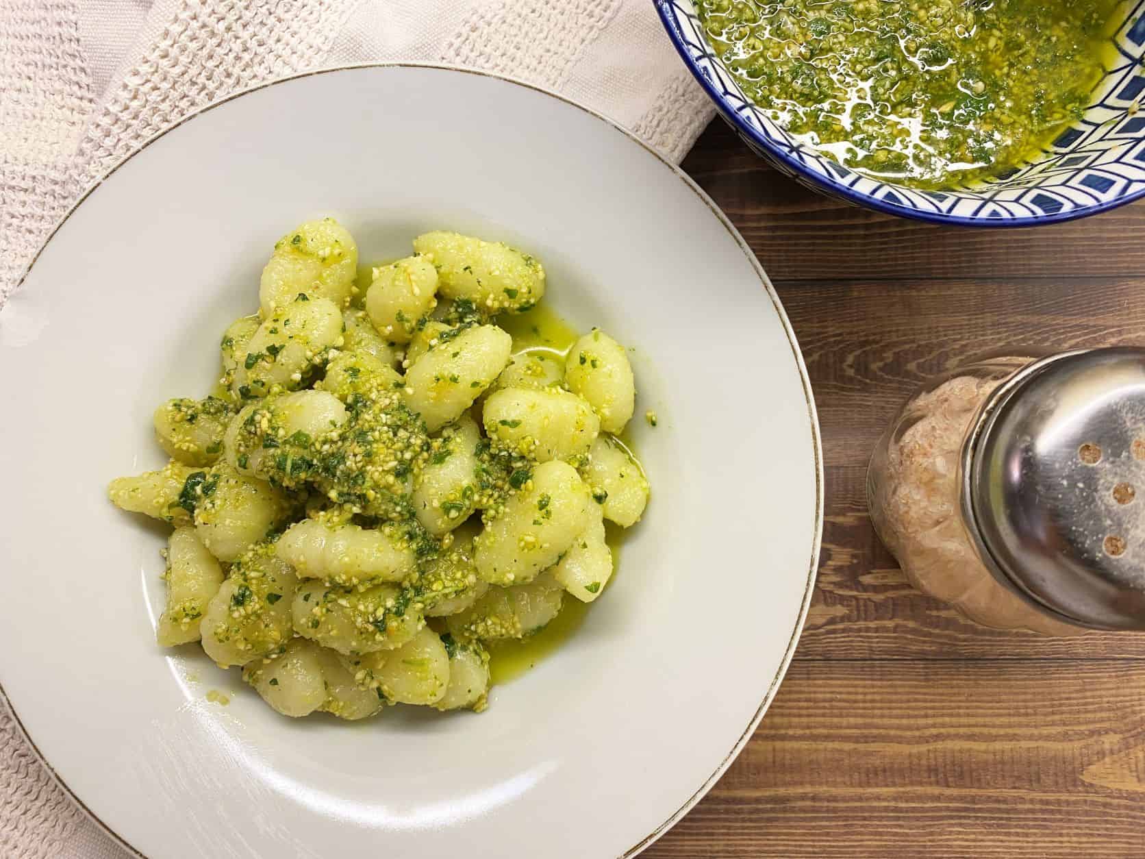 gnocchi with dairy free pesto sauce in a white bowl