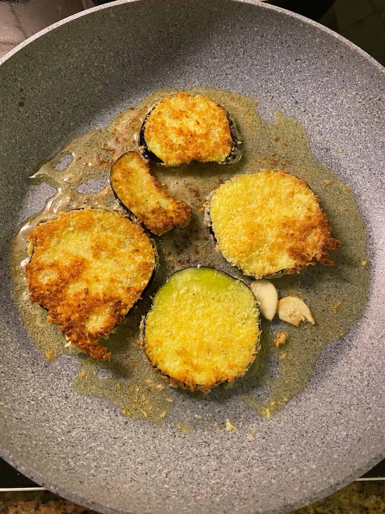 breaded eggplant frying in a pan