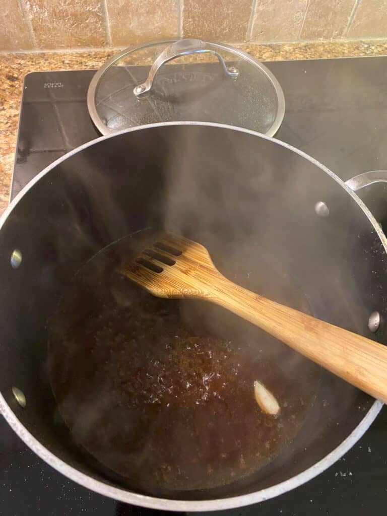 deglazing a large pot with red wine vinegar