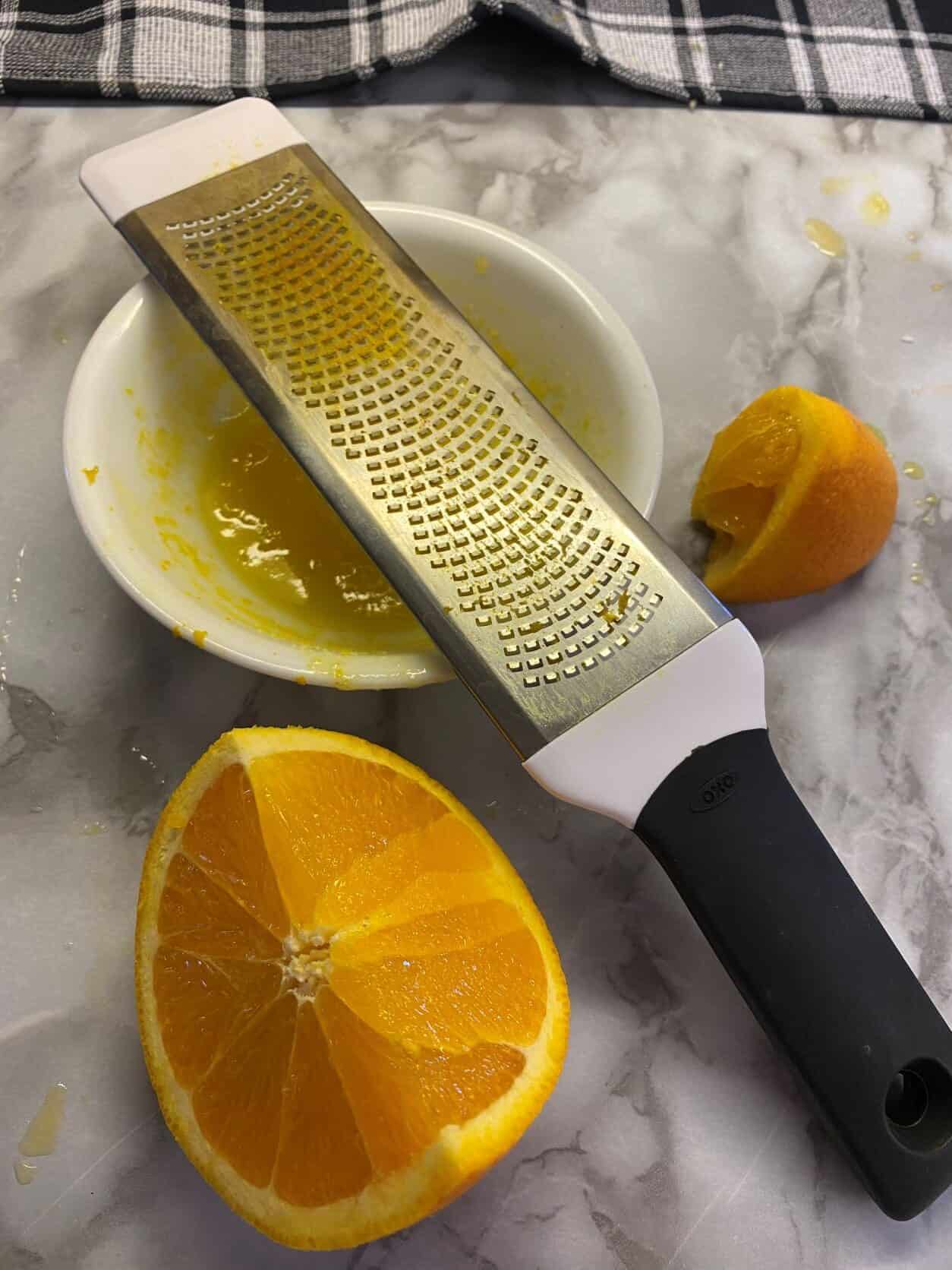Grater on a white plate with orange