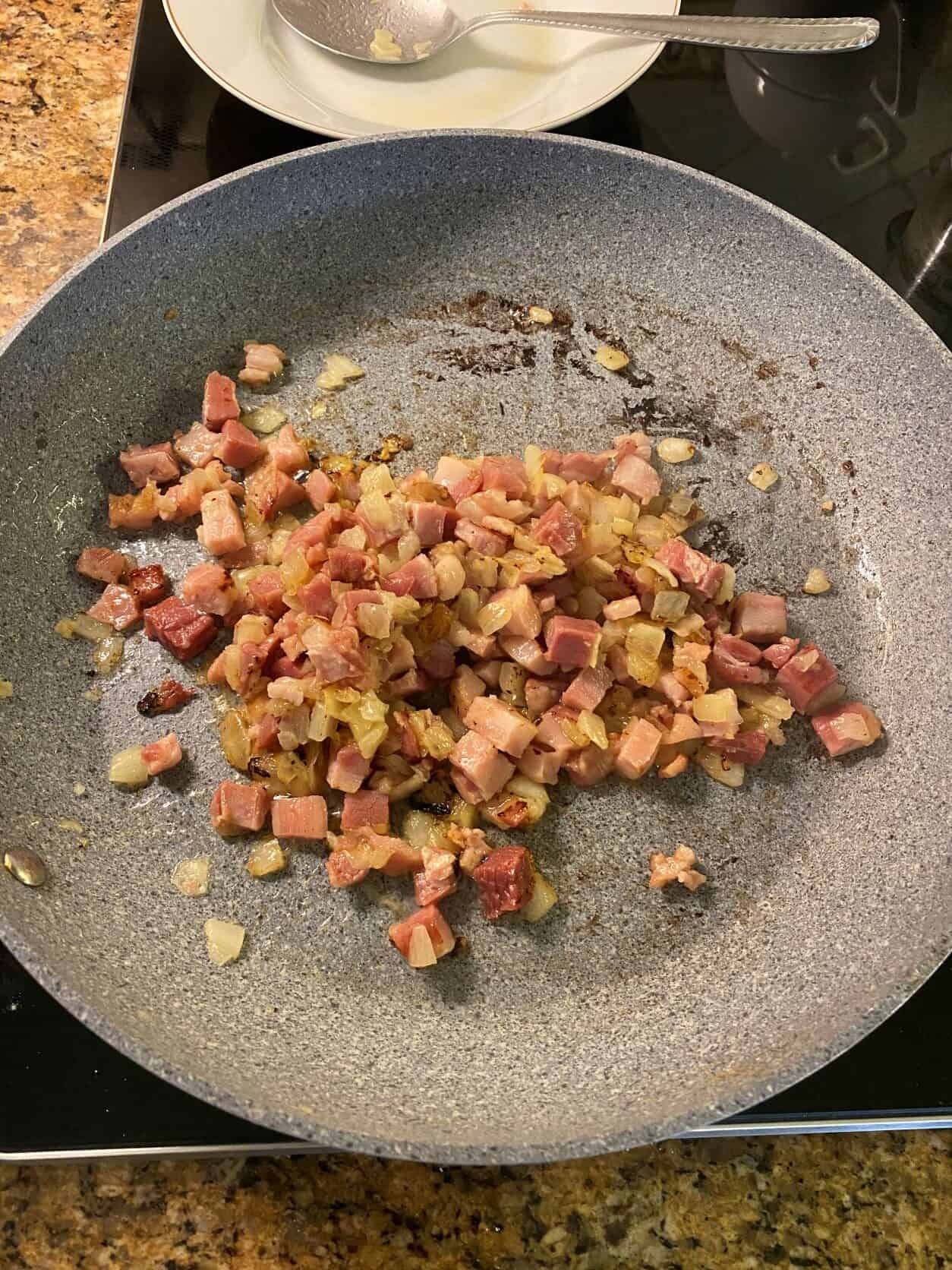 onion and pancetta in a skillet