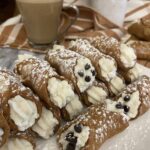 Cannoli filled with ricotta cheese in a white platter
