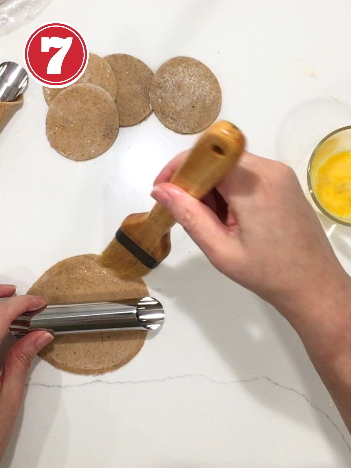 brushing egg wash on cannoli dough