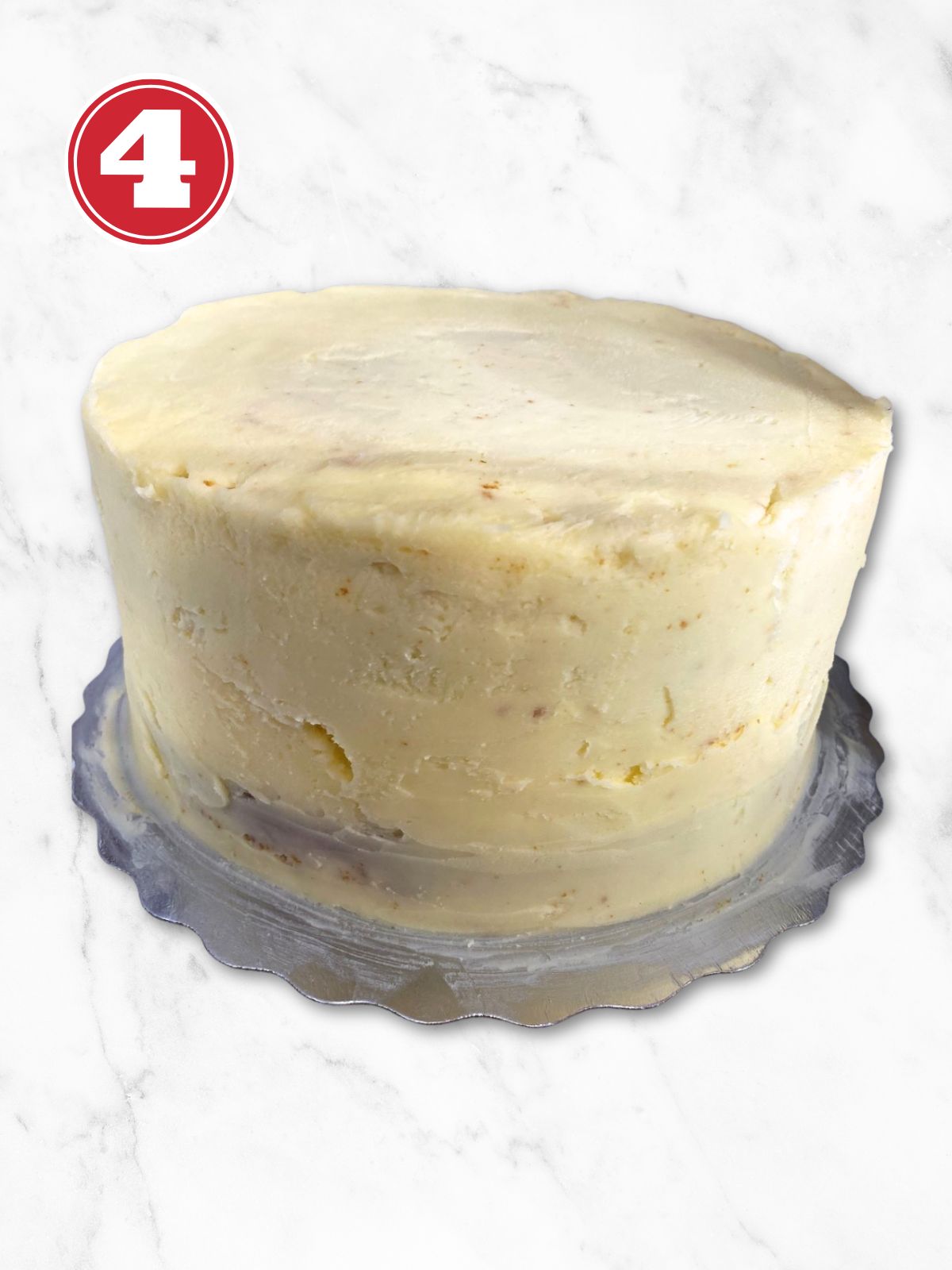 cannoli cake with icing on it on a cake board