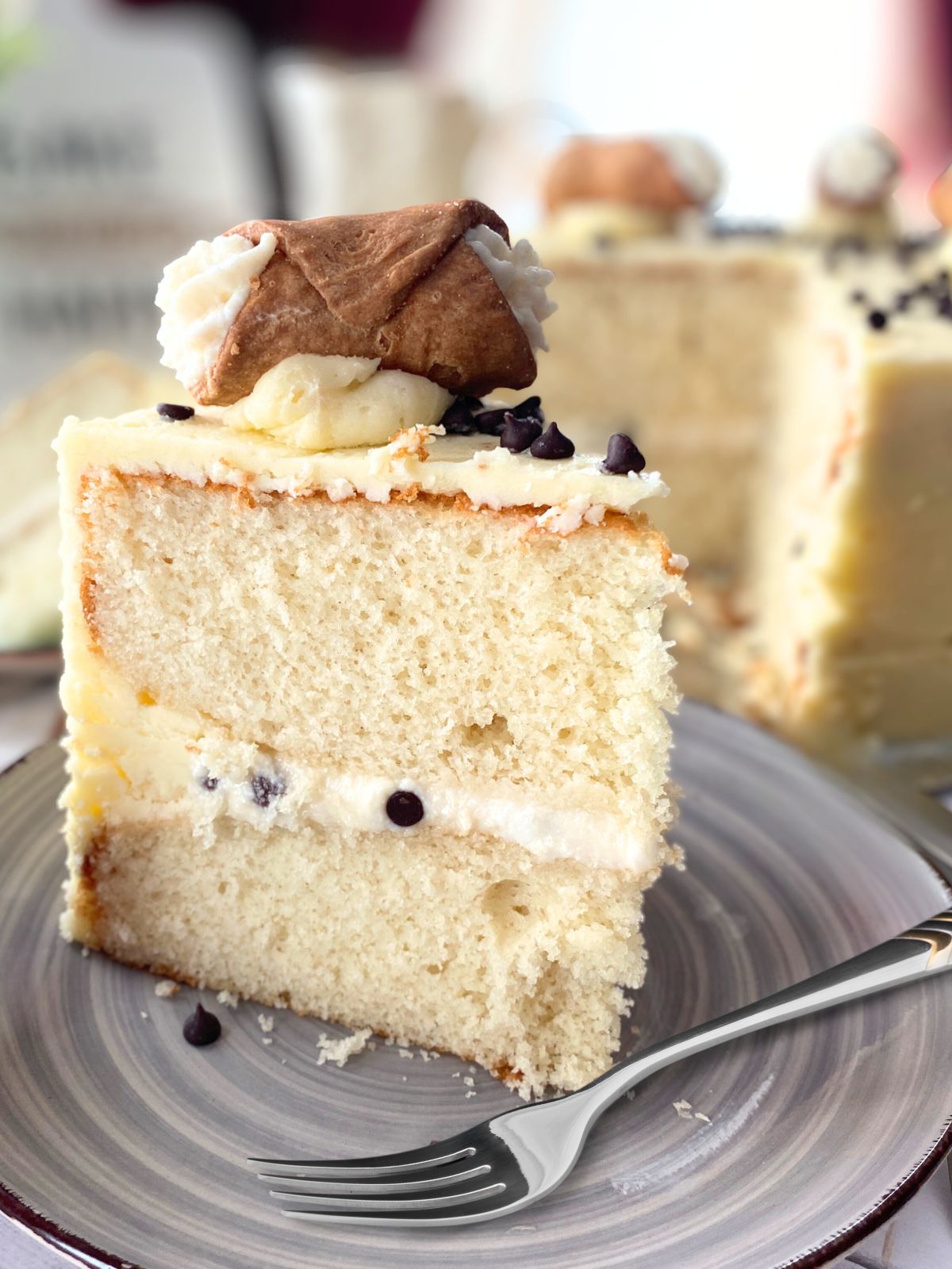 Slice of Cannoli cake on a grey dish
