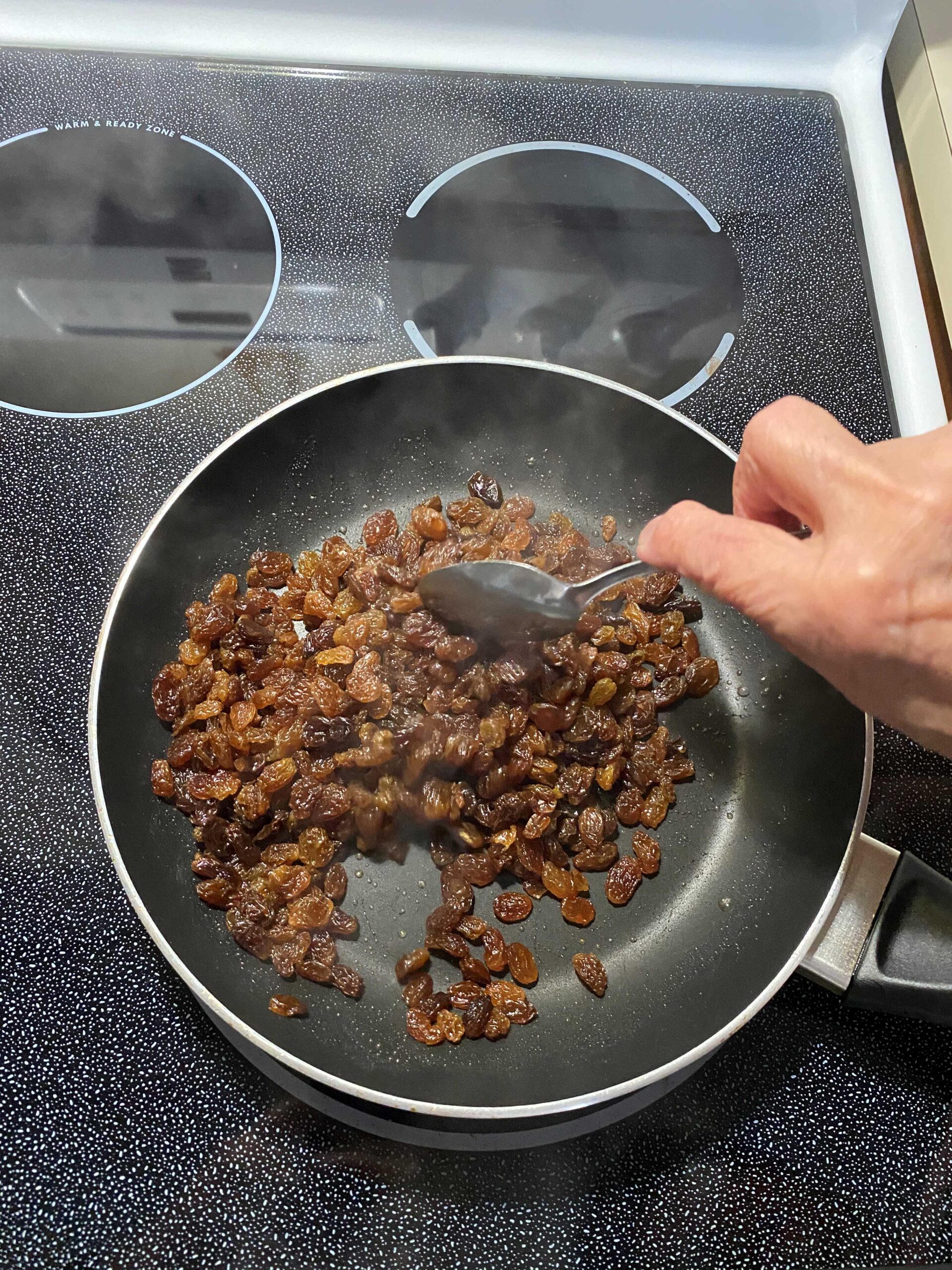 rehydrating raisins in frypan with a simple syrup