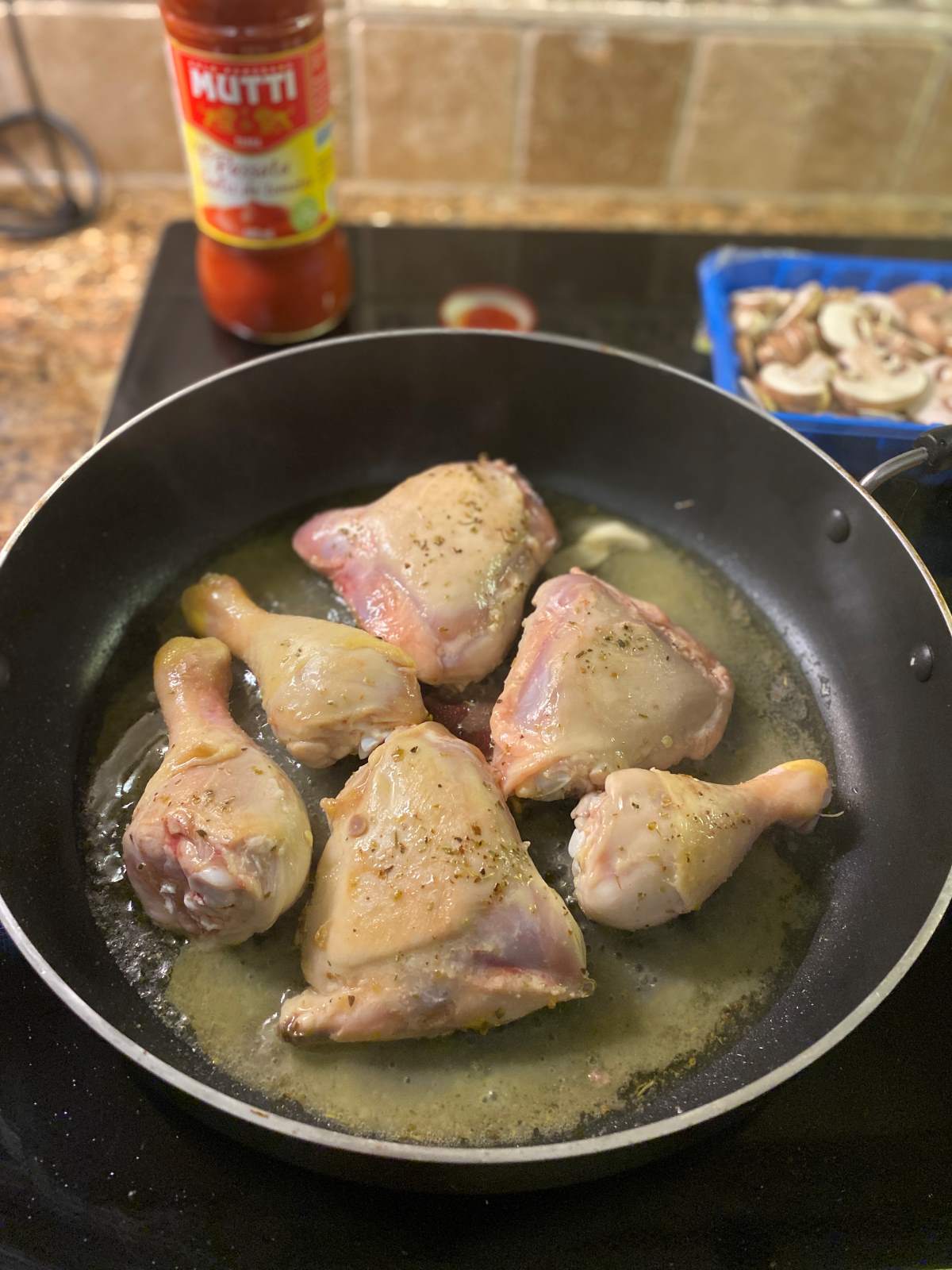 Chicken legs and thighs in a skillet frying