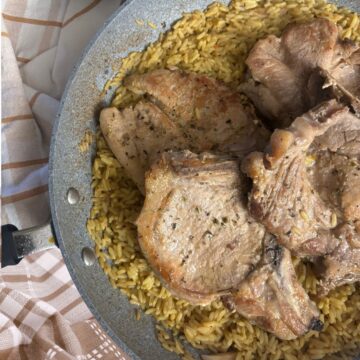 Pork chops in a fry pan with rice