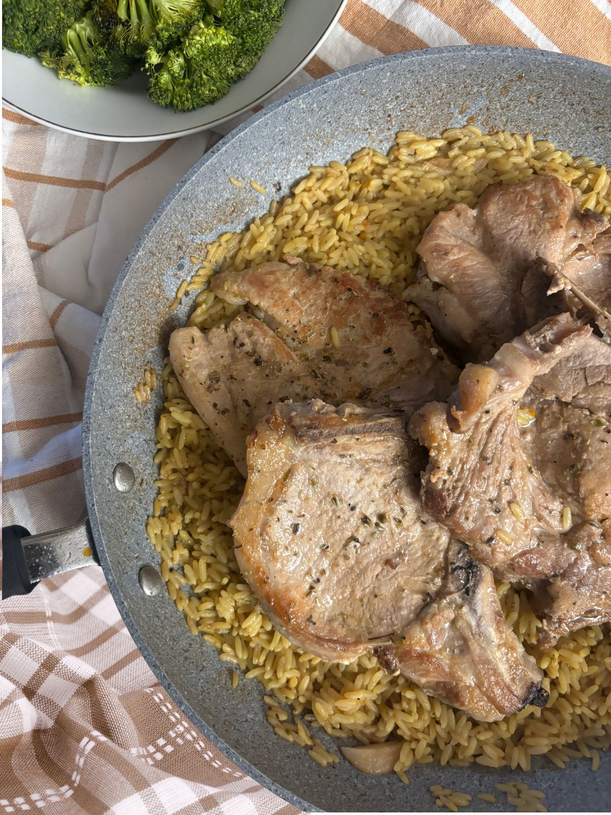 Pork chops in a fry pan with rice