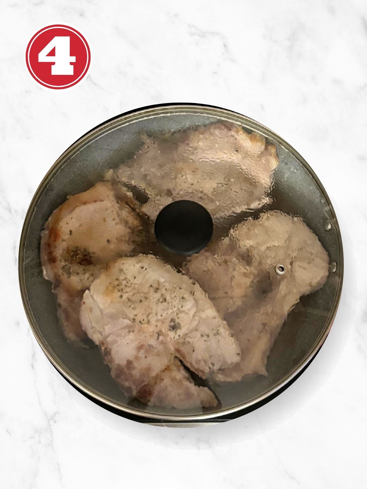 Seared Pork Chops Covered Simmering in a fry pan