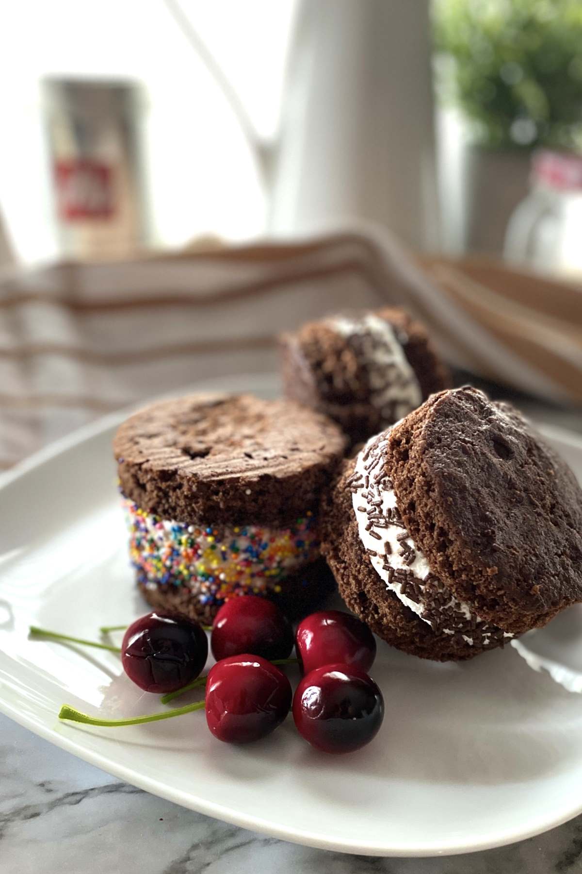 Chocolate Sandwich filled with Ice cream on a white plate with cherries