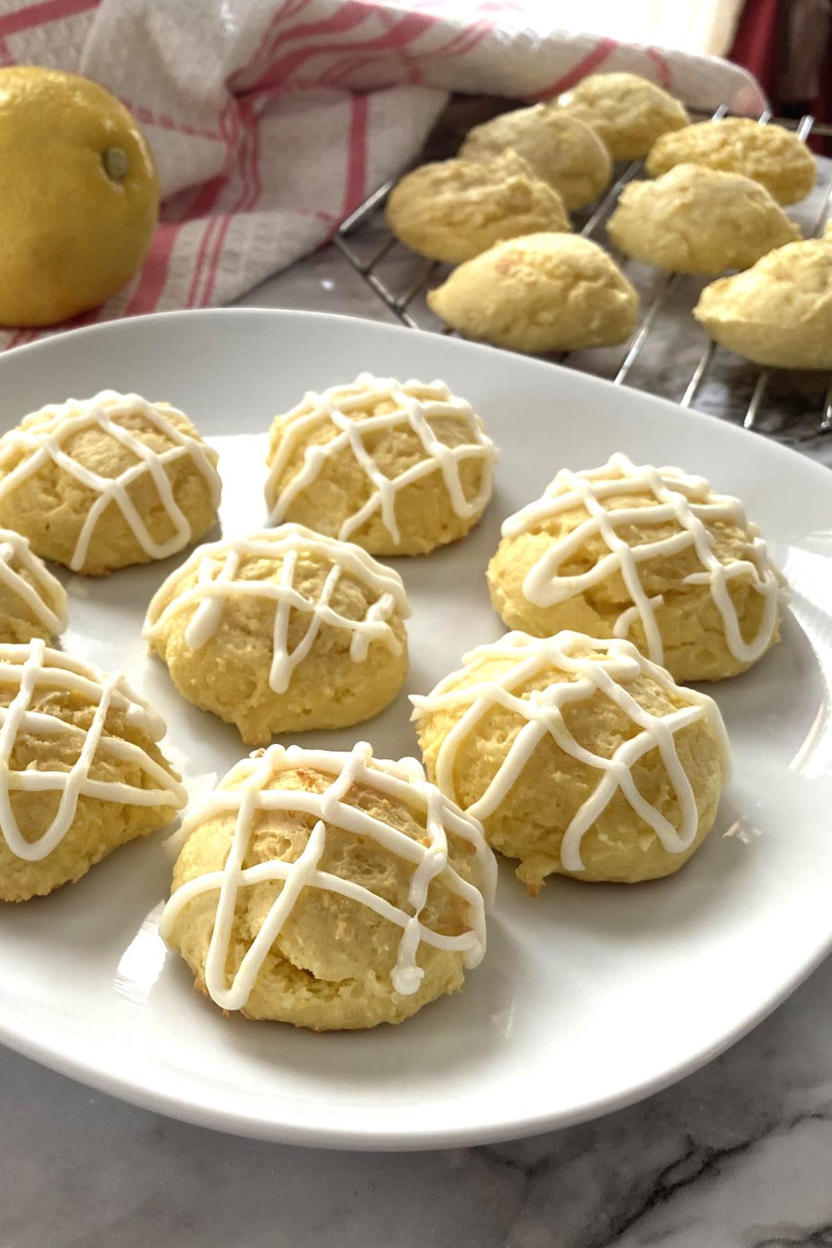 lemon drop cookies with lemon glaze on a white plate