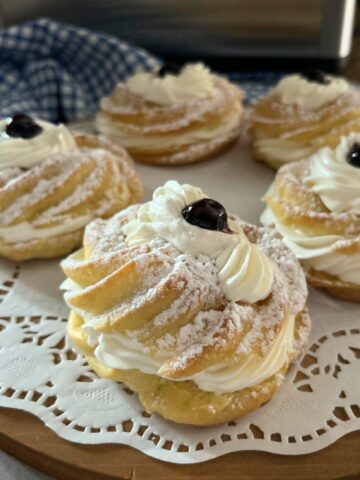 Zeppole filled with pastry cream and powdered sugar on top