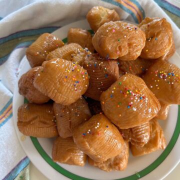 Calabrian Turdilli with Honey and sprinkles in a white plate