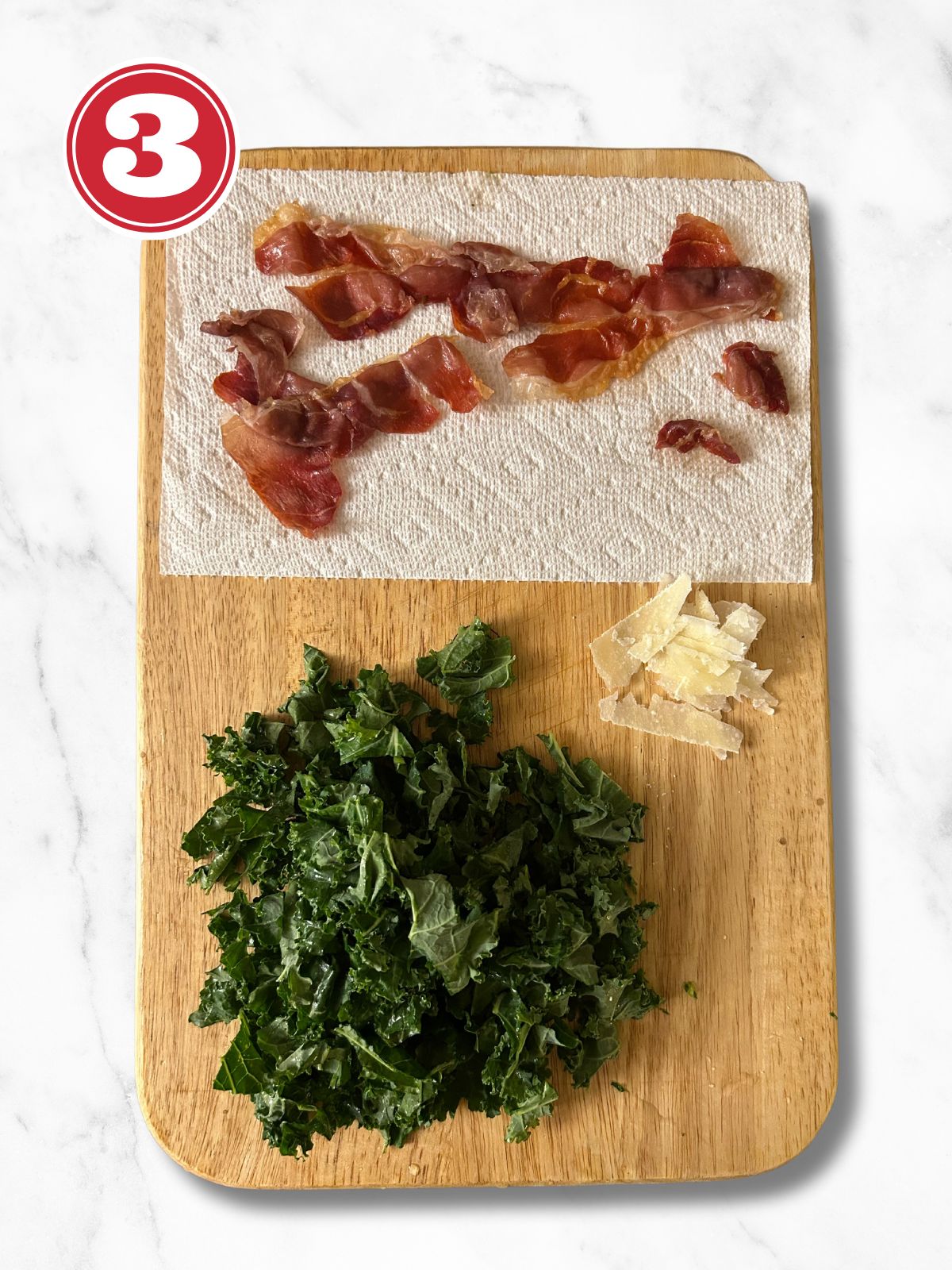 prosciutto, kale and parmesan shavings on a cutting board