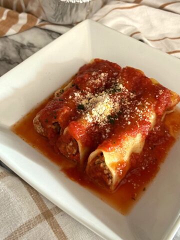 Meata Cannelloni in a white plate with marinara