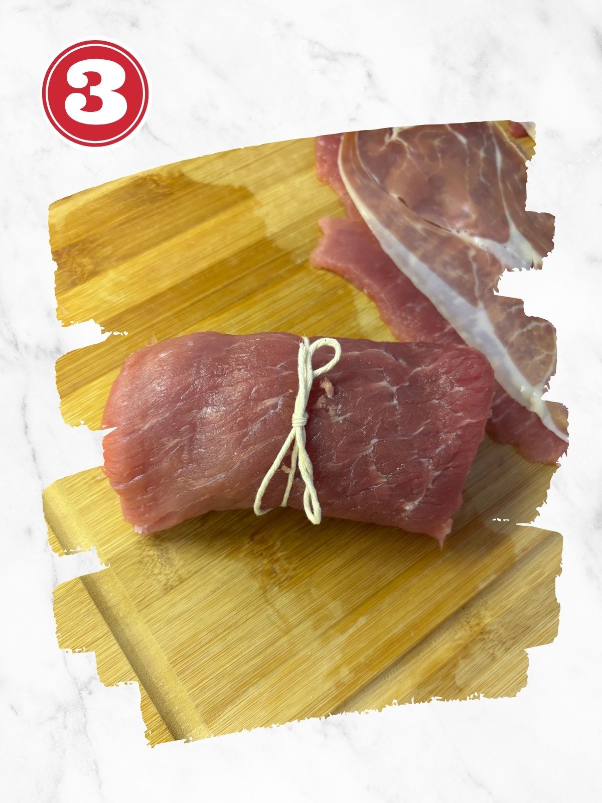 rolled up pork braciole tied with string on cutting board