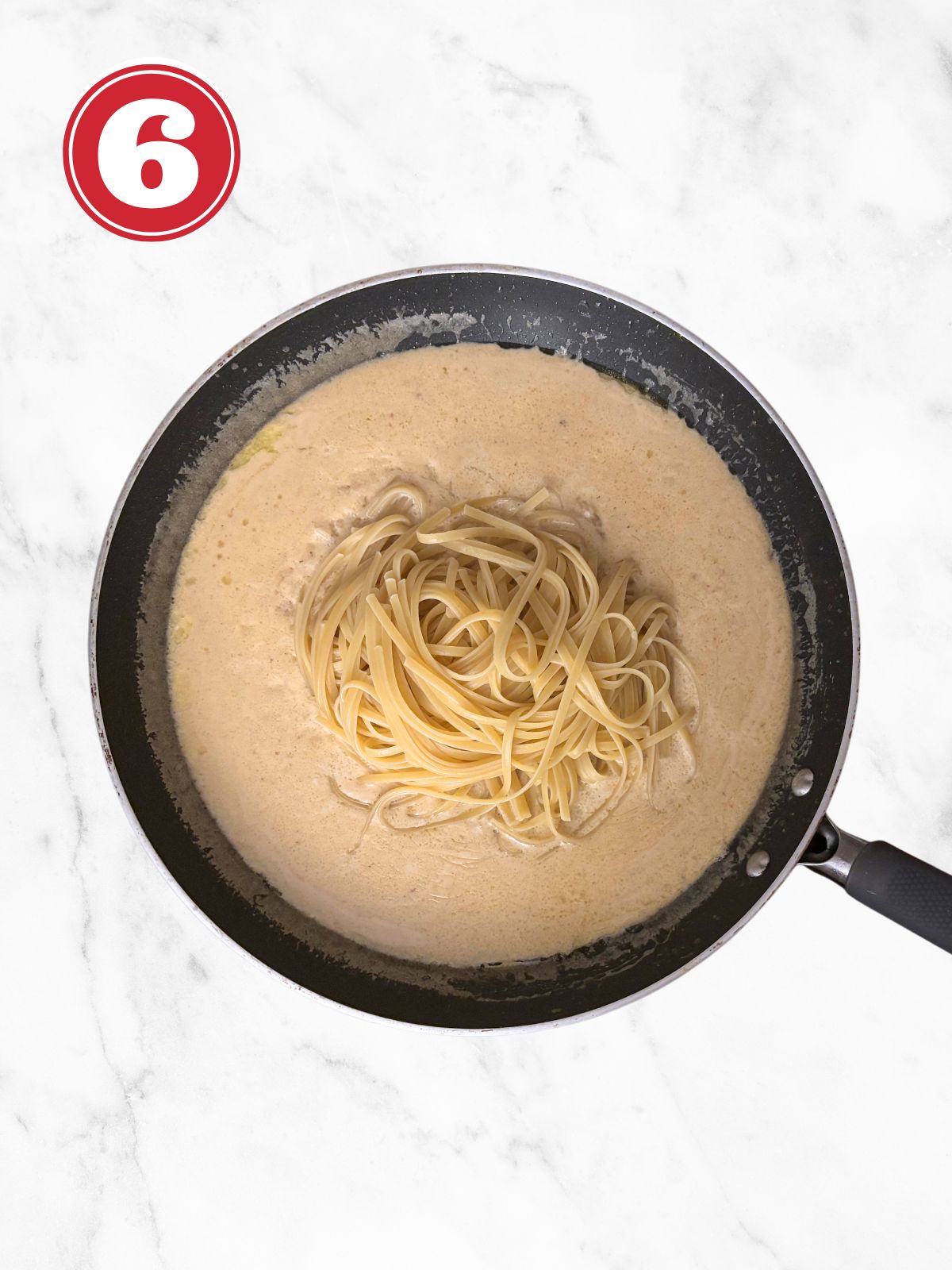linguini in creamy garlic parmesan sauce in a skillet