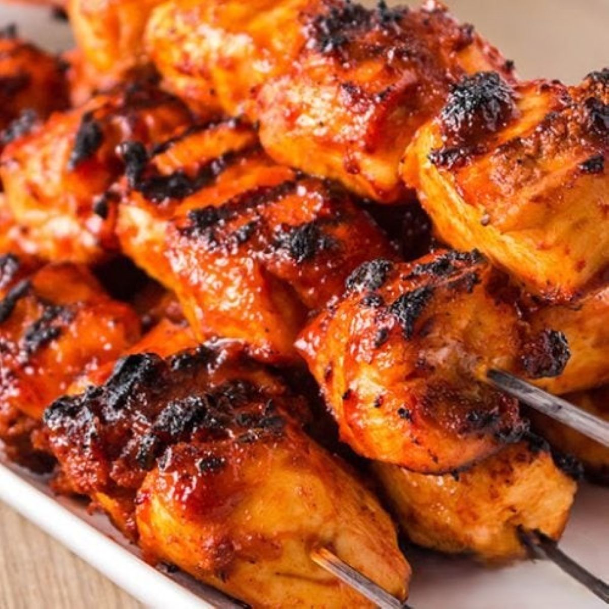Chicken bourbon Skewers on a white platter