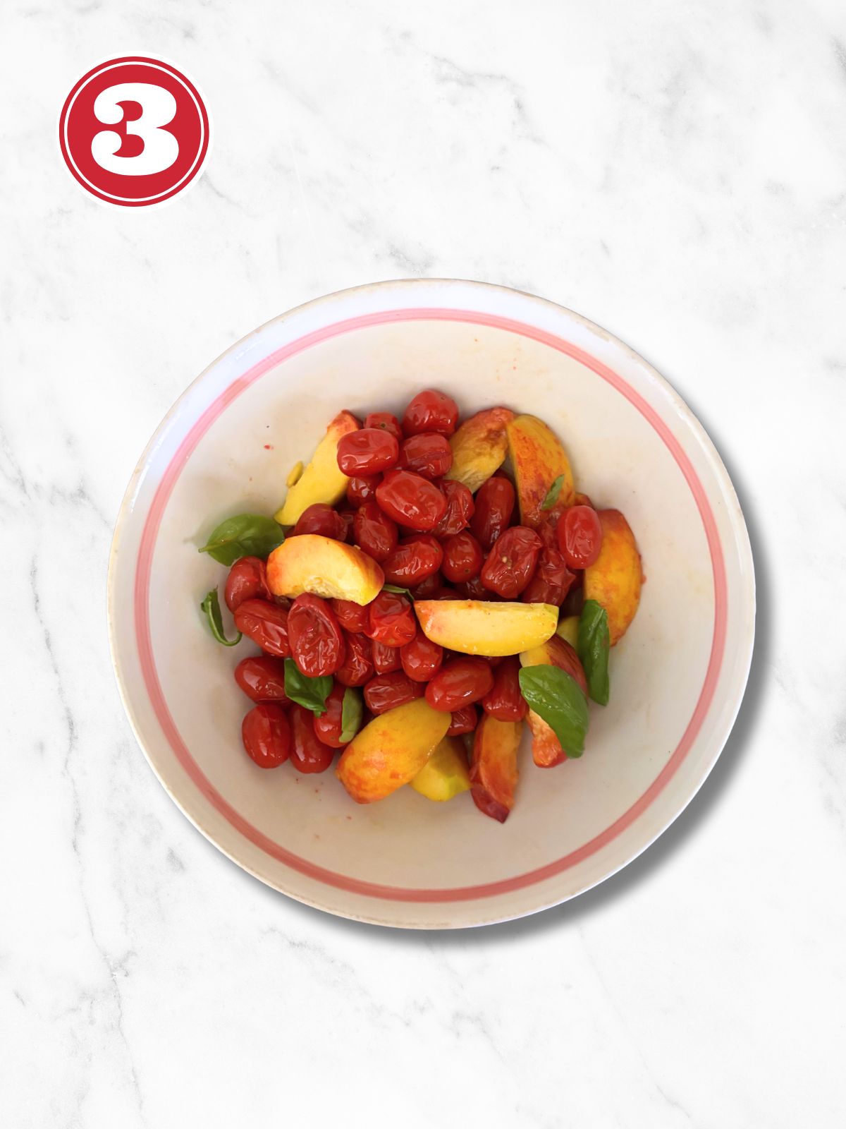 roasted cherry tomatoes and peach in a while bowl with fresh basil