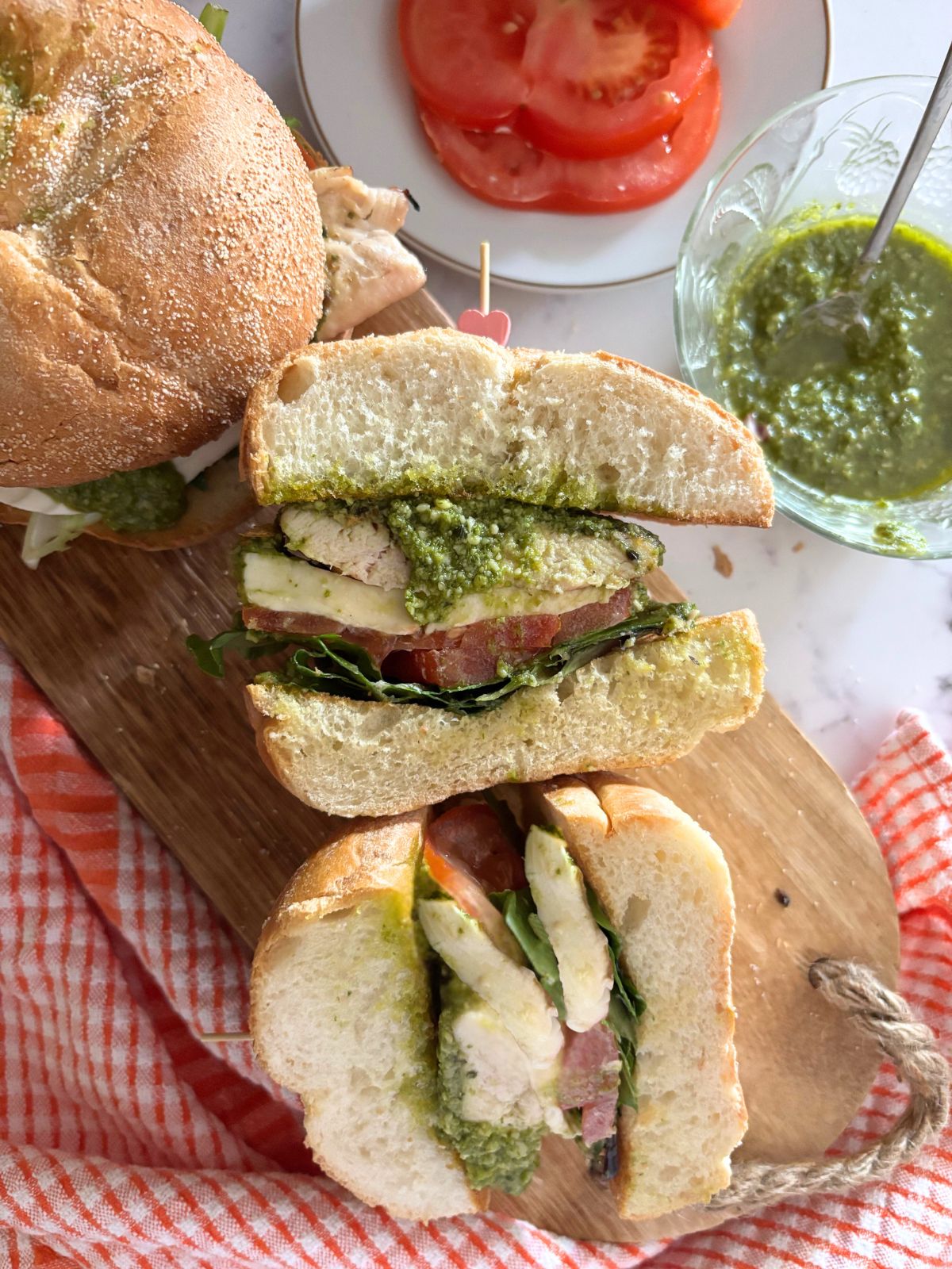 caprese chicken sandwich on a wooden cutting board