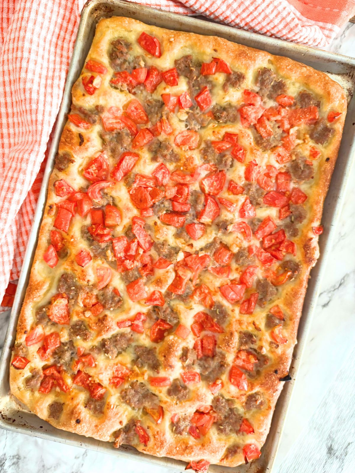 cooked sausage pizza on a baking sheet
