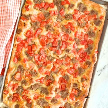 cooked sausage pizza on a baking sheet