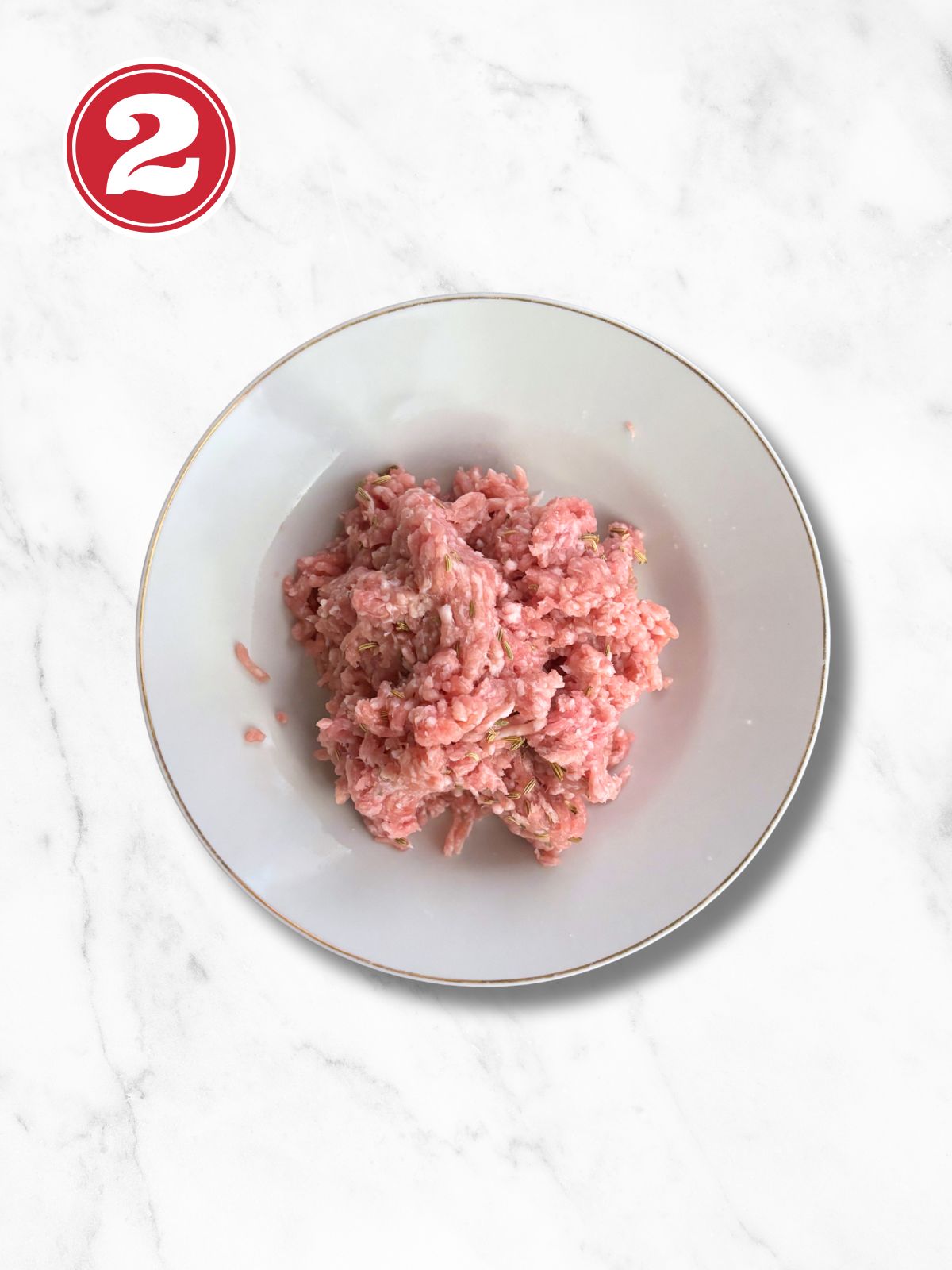 ground pork with fennel and seasoning in a white bowl