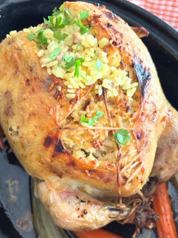 roast chicken stuffed under the skin in a black roasting pan