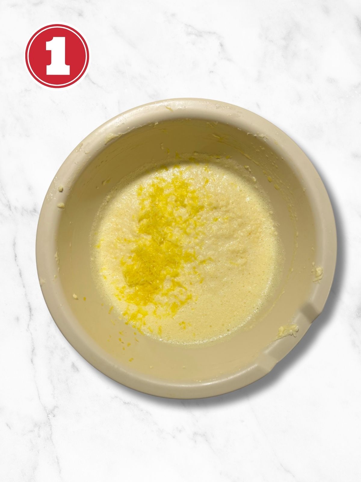 butter, eggs and grated lemon in a beige bowl