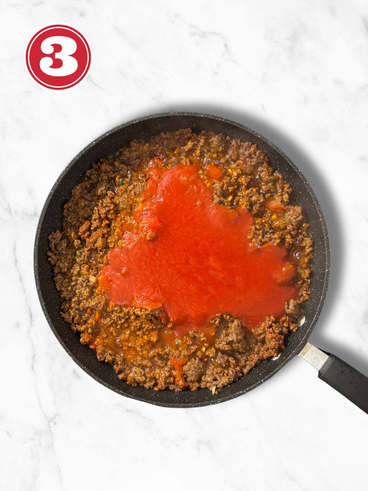 cooked ground beef in a skillet with tomato passata