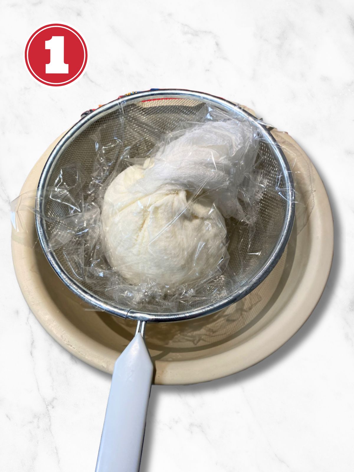 draining ricotta in cheesecloth and strainer over a bowl